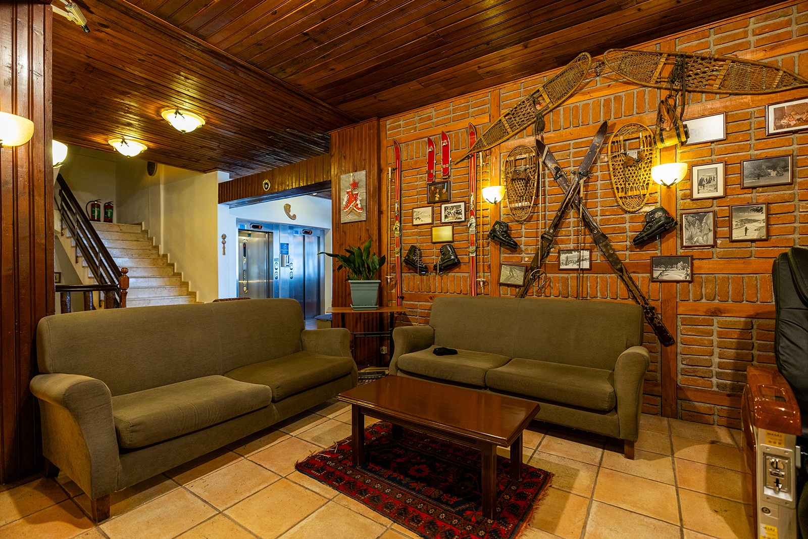 Beceren’s lounge with timber ceiling, brick walls, seating, skis and snowshoes